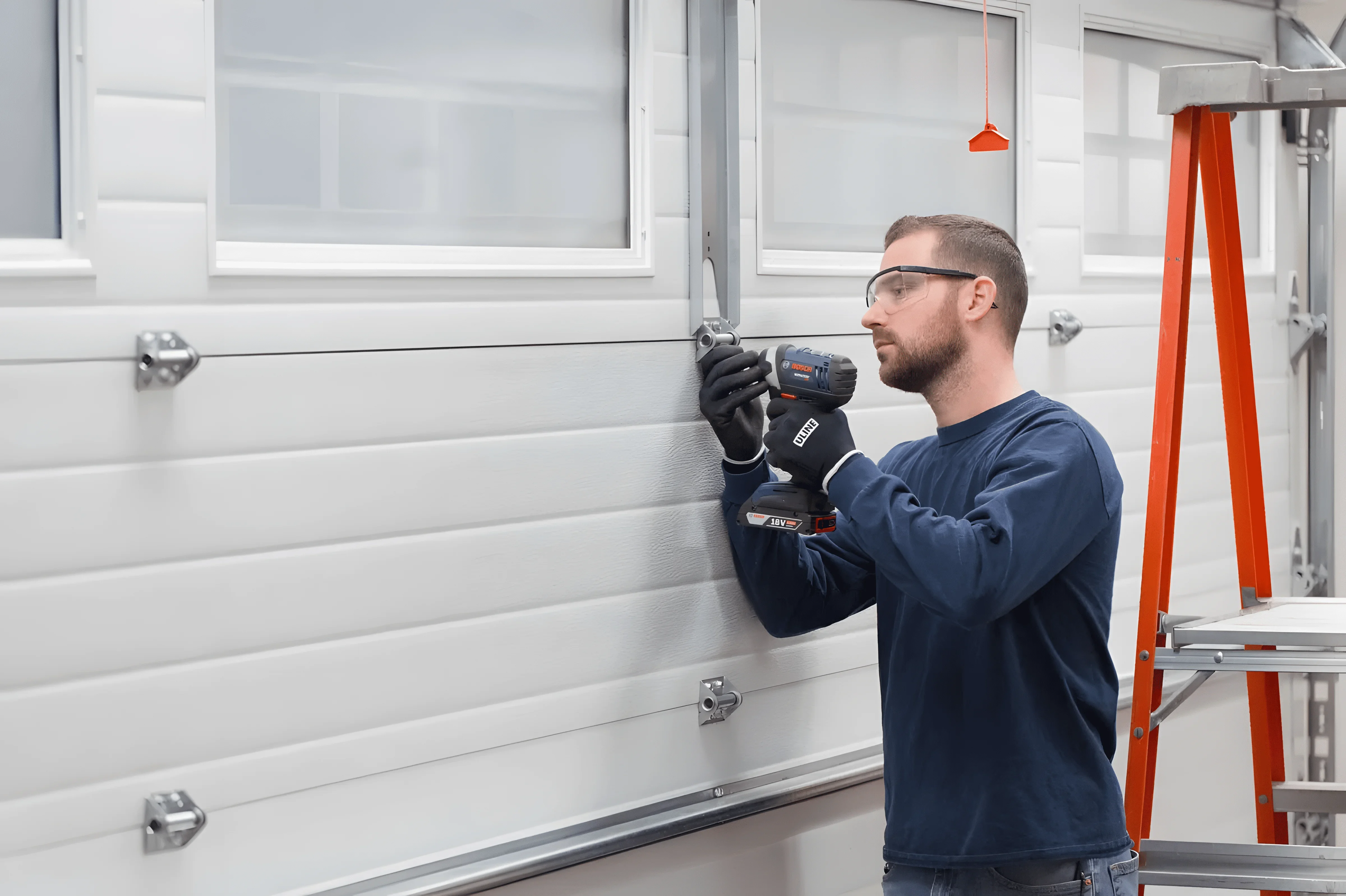 Man installing a garage door with a power tool