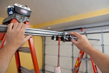 Person installing garage door opener components